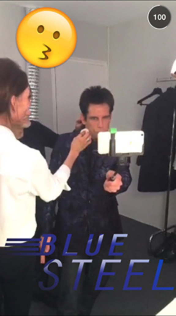 Person taking selfie with a selfie stick and blue steel text overlay.